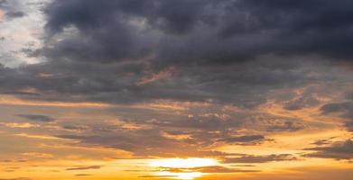 bleu ciel et orange lumière du soleil à travers les nuages dans le ciel photo