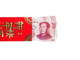 billets de banque chinois ou 100 yuans d'argent dans une enveloppe rouge isolé sur fond blanc, texte chinois sur enveloppe signifiant joyeux nouvel an chinois, chemin de détourage photo