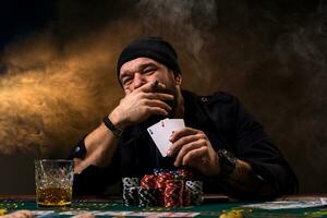 homme est en jouant poker avec une cigare et une whisky, une homme spectacle deux cartes dans le main, gagnant tout le frites sur le table avec épais cigarette fumée. photo