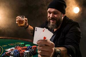 barbu homme avec cigare et verre séance à poker table dans une casino. jeu, en jouant cartes et roulette. photo