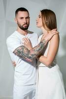 portrait de une magnifique Jeune couple dans l'amour posant à studio plus de blanc Contexte. photo