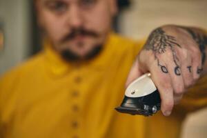 élégant coiffeur homme avec coiffure outils dans le sien mains préparer pour travail photo