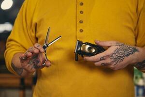 élégant coiffeur homme avec coiffure outils dans le sien mains préparer pour travail photo