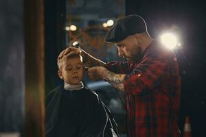 caucasien garçon avoir la Coupe de cheveux dans salon de coiffure intérieur photo