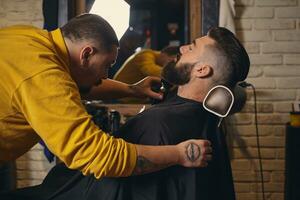 client avec gros noir barbe pendant barbe rasage dans coiffeur magasin photo