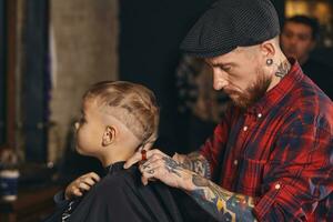 caucasien garçon avoir la Coupe de cheveux dans salon de coiffure intérieur photo