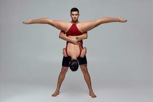 le couple de un athlétique moderne ballet danseurs sont posant contre une gris studio Contexte. photo