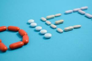 régime mot de coloré médicament pilules isolé sur bleu arrière-plan, supplément, vitamine, coloré photo