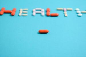 rouge médicament pilule sur santé mot flou Contexte bleu, supplément, vitamine, coloré photo