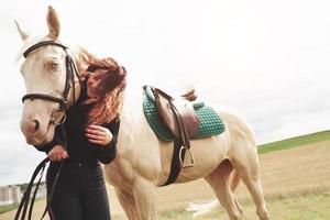 une fille heureuse communique avec son cheval préféré. la fille aime les animaux et l'équitation