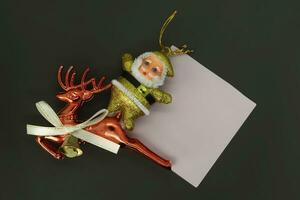 Père Noël claus et renne avec Vide papier sur noir Contexte. photo