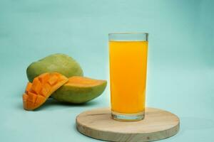 mangue boisson sur rond plateau avec mangue fruit sur bleu Contexte photo