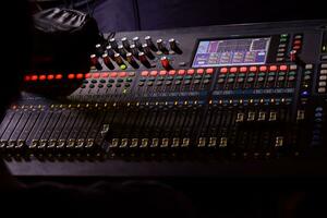 une homme surveillance curseurs sur le l'audio console. photo