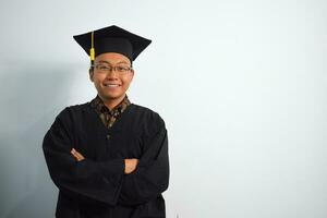 expressif de adulte Indonésie Masculin porter l'obtention du diplôme peignoir, chapeau et lunettes isolé sur blanc arrière-plan, expressions de portrait l'obtention du diplôme photo