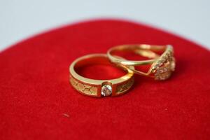 proche en haut d'or bague avec diamant sur rouge tapis Contexte photo