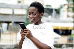 jeune femme écrit des messages sur son téléphone portable. photo