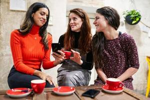 groupe de trois amis heureux buvant du café dans un café-bar. photo