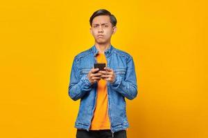 jeune homme asiatique choqué regardant un message sur un smartphone photo