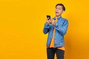 jeune homme asiatique choqué regardant un message sur un smartphone photo