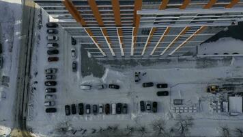 aérien Haut vue de le typique Résidentiel zone avec beaucoup voitures garé par le haute monter bâtiment. vidéo. détails de une Résidentiel maison et une neige couvert route, gros ville la vie dans l'hiver. photo