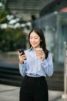 Jeune asiatique affaires femme chef entrepreneur, professionnel directeur en portant numérique tablette ordinateur uon le rue dans gros ville photo