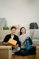 asiatique Jeune attrayant couple homme et femme utilisation tablette et téléphone intelligent en ligne achats meubles décorer maison avec carton paquet bouge toi photo