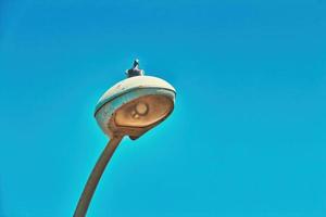 L'oiseau pigeon se dresse et se repose sur un lampadaire de rue à tel aviv le jour ensoleillé d'été avec un beau ciel clair photo