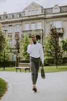 jeune homme d'affaires afro-américain à l'aide d'un téléphone mobile dans une rue photo