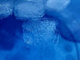 la glace cubes isolé sur bleu Contexte photo