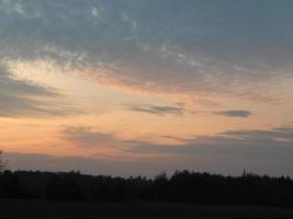 coucher de soleil sur la forêt naturelle et les champs au crépuscule photo