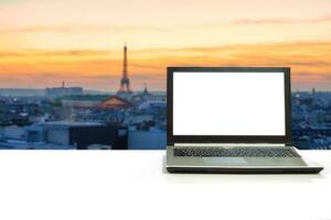 portable sur blanc bureau avec flou Eiffel la tour dans Paris à le coucher du soleil photo