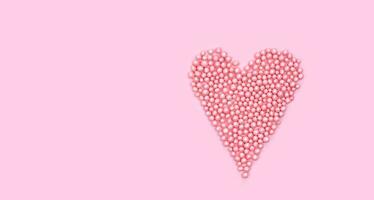 cœur forme fabriqué de petit rose des balles sur rose Contexte. Créatif composition pour la Saint-Valentin journée. Haut voir. copie espace. photo