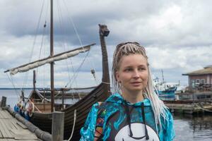 femelle touristique vient à terre après voile sur une moderne réplique de un ancien viking navire photo