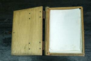 vieux Journal livre dans une en bois Cas avec fermoirs sur une noir dessus de la table, ouvert photo