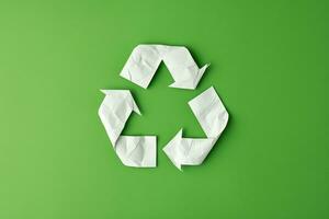 ai généré recycler symbole fabriqué de blanc papier sur vert Contexte photo