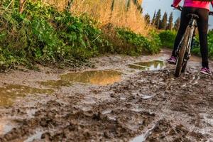 balade à vélo à travers un chemin de terre boueux photo