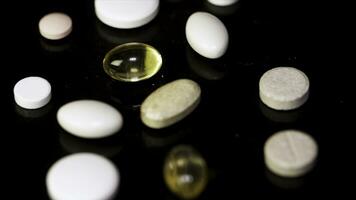 pilules filage. pile de nombreuses médicaments. blanc comprimés avec pilules sur noir Contexte. ouvert médicament capsule pilule photo