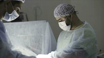 détails de une réel chirurgie dans le stérile en fonctionnement théâtre. action. médical Contexte de médecins portant stérile uniforme et visage masque à travail à le hôpital. photo