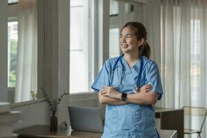 souriant femelle médecin portant une stéthoscope dans le médecins Bureau dans le hôpital photo