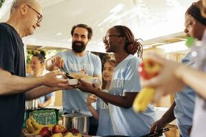 généreuse bénévoles à nourriture banque, distribuer essentiel articles et aliments à nécessiteux. charité groupe donnant repas des dons, portion défavorisé et sans abri gens avec la compassion et gentillesse. photo