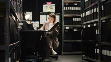 dévoué femelle privé détective avec précision conduit recherche pour des indices et information. en utilisant La technologie dans Bureau chambre, caucasien police officier examine preuve des dossiers et Est-ce que légal analyse. photo