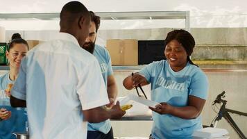 bénévoles partage gratuit nourriture et autre nécessités à le faim et Moins privilégié. amical humanitaires faire un don repas et fournir assistance à le pauvres et sans abri personnes. trépied tir. photo