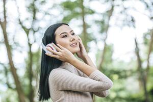 femme asiatique écoutant sa musique préférée au casque. bon moment et détendez-vous. photo