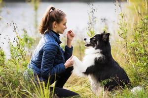 jolie fille dans une veste bleue est assise devant son chien photo