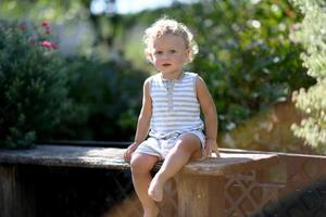 Beau petit garçon dans le jardin de l'enfant photographe posant photo