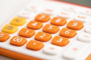 pavé numérique sur la calculatrice de couleur orange pour la finance de compte au bureau. photo