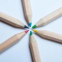 crayons en bois colorés disposés en forme d'étoile radiale symétrique, vus d'en haut. fond blanc. concept de retour à l'école. photo
