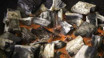vue de chaud flamboyant charbon briquettes embrasé dans le un barbecue gril fosse. brûlant charbons pour cuisine barbecue aliments. proche en haut photo
