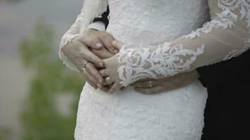 la mariée détient une mariage bouquet dans mains, le jeune marié câlins sa de derrière. jeune marié étreindre le la mariée de derrière photo