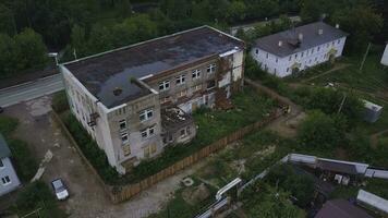 Haut vue de abandonné brique bâtiment dans Résidentiel zone. agrafe. brique bâtiment des stands abandonné sur faubourgs de ville. abandonné brique bâtiment près Résidentiel bâtiments dans ville près forêt photo